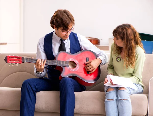 The young woman during music lesson with male teacher