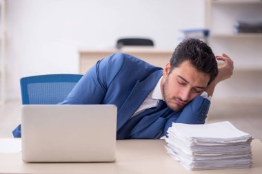 Genç işadamı ve işyerinde çok fazla iş var.