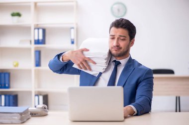 Genç işadamı ve işyerinde çok fazla iş var.