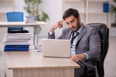 Genç işadamı ve ofiste çok fazla iş var.