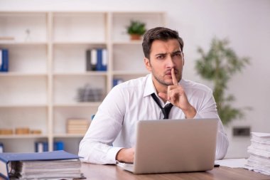 Genç işadamı işyerinde oturuyor.