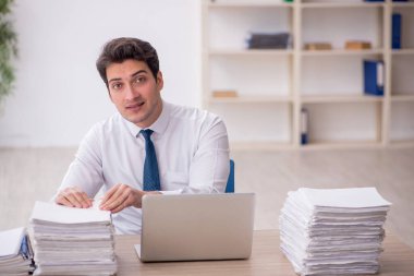 Genç işadamı ve işyerinde çok fazla iş var.