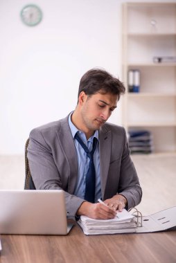 Genç işadamı işyerinde oturuyor.