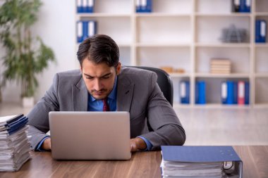 Genç işadamı işyerinde oturuyor.