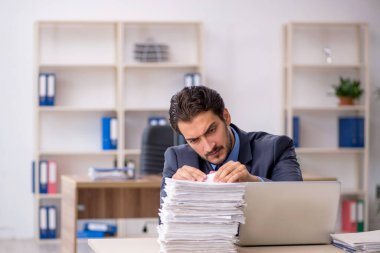 Genç işadamı ve ofiste çok fazla iş var.