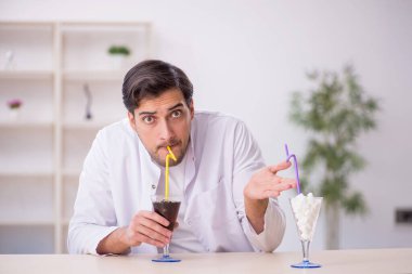 Laboratuvarda alkolsüz içeceği inceleyen genç bir kimyager.