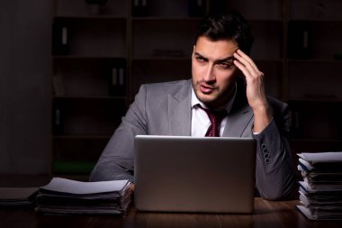Young employee working late at workplace