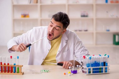 Young chemist sitting at the lab