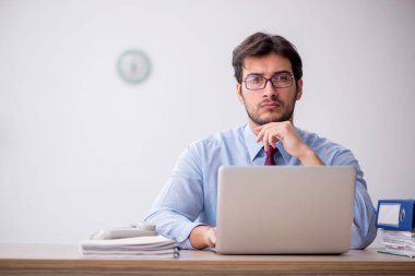 Genç işadamı işyerinde oturuyor.