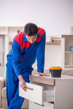 Evde çalışan genç bir marangoz.