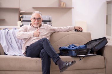 Aged man preparing for trip at home
