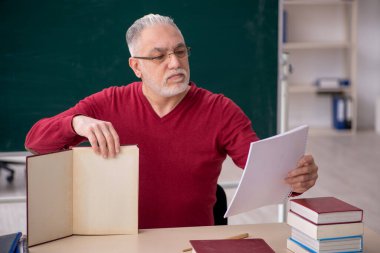 Old teacher sitting in the classroom