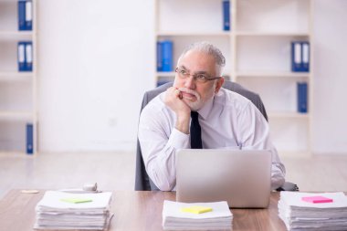 Old businessman employee unhappy with excessive work at workplace