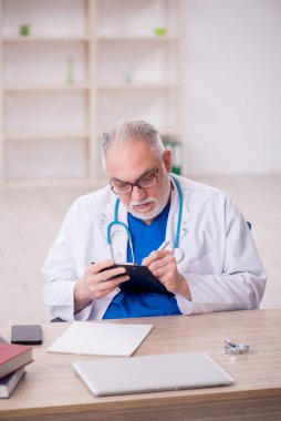 Old doctor sitting at the hospital