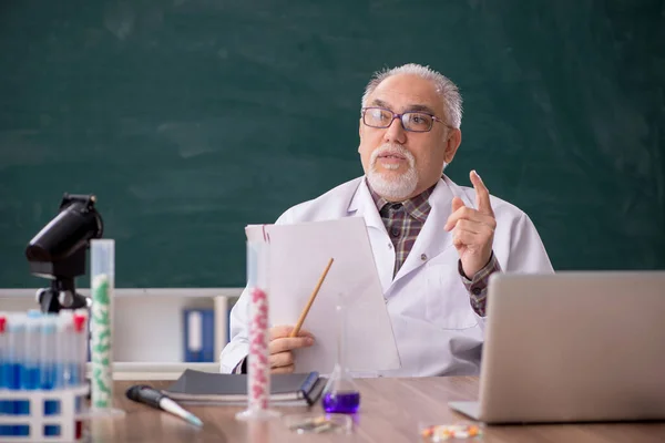 教室に座っていた古い先生の化学者 — ストック写真
