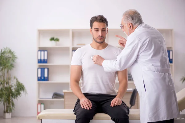 Paciente Joven Visitando Viejo Médico Masculino — Foto de Stock