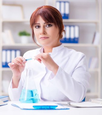 Laboratuvarda bir deney yürüten kadın bilim adamı.