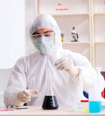 Laboratuvarda çalışan genç yakışıklı kimyager.