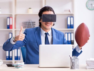 The young handsome businessman playing rugby with virtual glasses