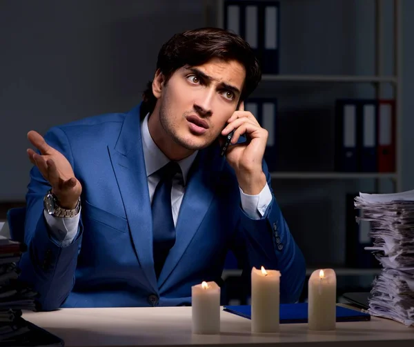 stock image The businessman working late in office with candle light