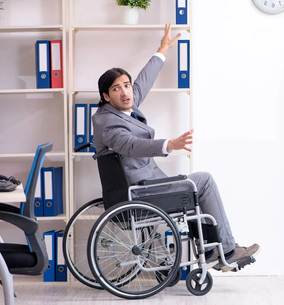 オフィスで働く車椅子の若いハンサムな従業員 — ストック写真