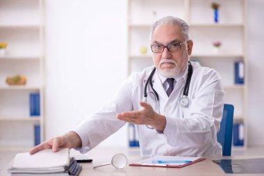Klinikte çalışan yaşlı bir doktor.