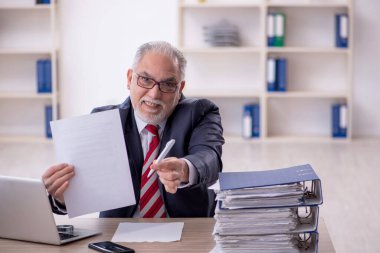 Ofisteki aşırı işten memnun olmayan eski bir işadamı.