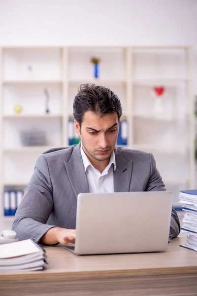 stock image Young businessman employee and too much work in the office