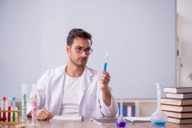 Young chemist in front of white board