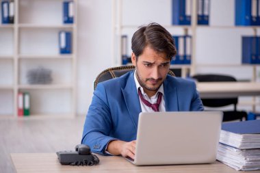 Genç işadamı ve ofiste çok fazla iş var.