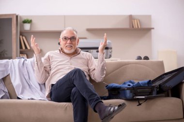 Aged man preparing for trip at home