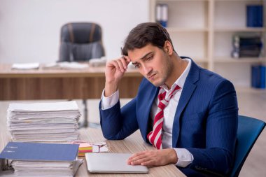 Genç işadamı ve ofiste çok fazla iş var.