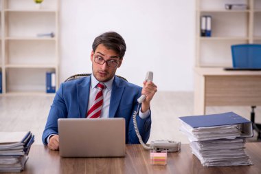 Genç işadamı işyerinde oturuyor.