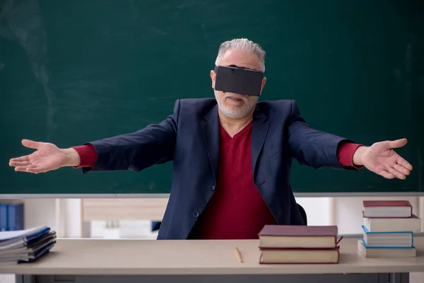 在教室里戴虚拟眼镜的老教师 — 图库照片