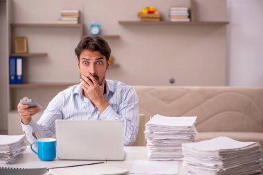 Genç erkek çalışan salgın sırasında evden çalışıyor.