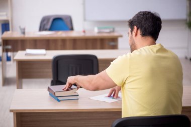 Young student teacher sitting in the classroom