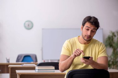 Young student teacher sitting in the classroom