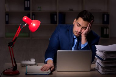 Young employee working late at workplace