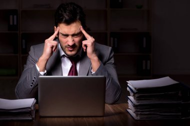 Young employee working late at workplace