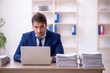 Genç işadamı ve ofiste çok fazla iş var.