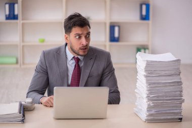 Young employee and too much work at workplace