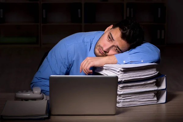 Young employee working late at workplace