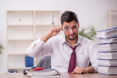 Genç bir çalışan ve ofiste çok fazla iş var.