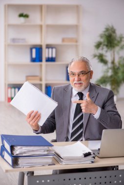 Ofiste çalışan eski bir işadamı.