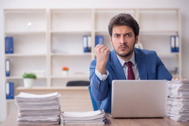 Young employee and too much work at workplace
