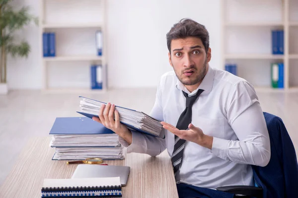 stock image Young businessman employee and too much work at workplace