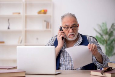 İş yerinde oturan yaşlı yazar.