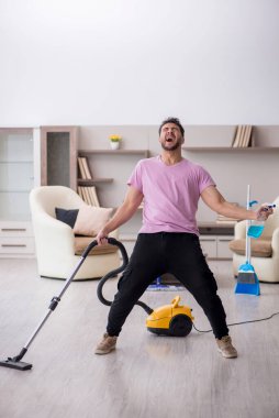 Genç müteahhit evi temizliyor.