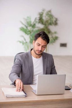 Genç çalışan işyerinde oturuyor.