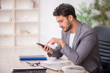 Genç çalışan işyerinde oturuyor.